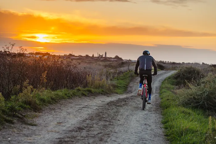 Un homme à vélo sur une piste cyclable au bord de mer