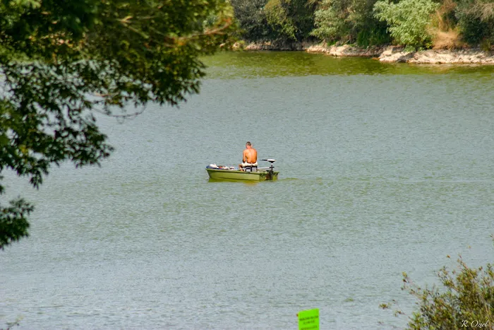 Pecheur profitant de sa barque sur un lac